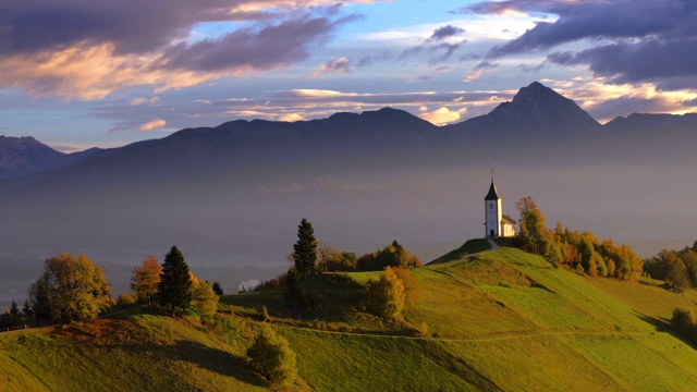 鸟瞰图的风景圣普里莫兹教堂附近的贾姆尼克，斯洛文尼亚和朱利安阿尔卑斯在背景视频下载