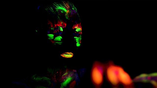 年轻女子的剪影与荧光印在脸上视频素材