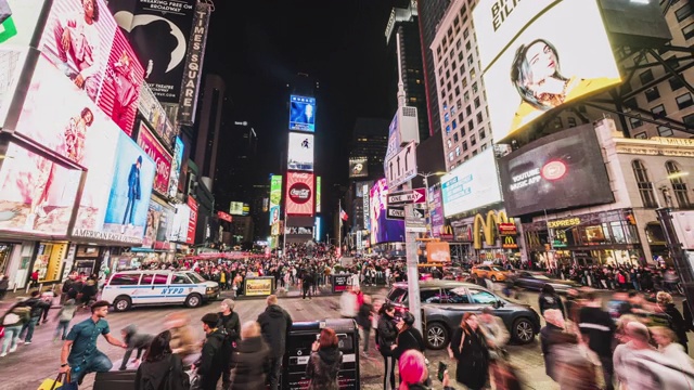 拥挤的人群，汽车交通和广告牌显示的广告在晚上在时代广场。美式生活方式或现代城市生活理念视频素材