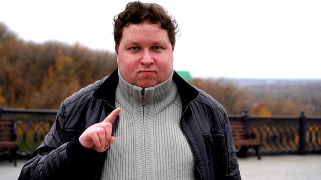 一个胖男人的肖像，打着“不”的手势。一个严肃的人举起手指说，不，你没做过。视频下载