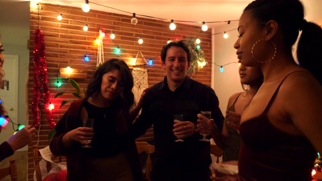 节日聚会时，朋友们在客厅里一起微笑跳舞视频下载