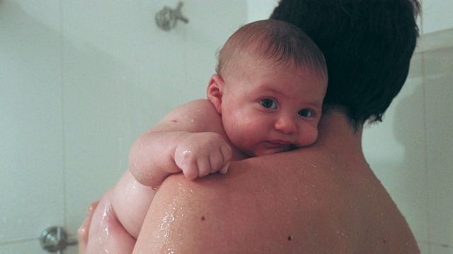 爸爸抱着刚出生的婴儿在淋浴视频素材