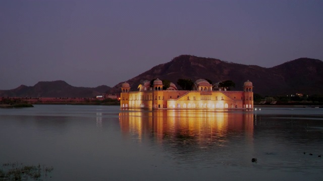 夜晚拍摄的一个美丽的jal mahal泛光灯照亮的湖，斋浦尔视频下载