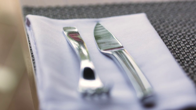 餐巾纸上的刀叉取代了餐桌上的晚餐在一个伟大的餐厅-近景-食物和饮食的概念视频下载