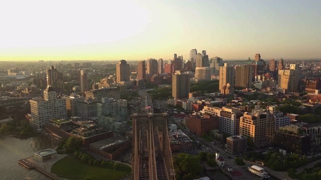 航拍:日出/日落时，带着美国国旗飞越布鲁克林大桥飞往布鲁克林(4K)视频素材