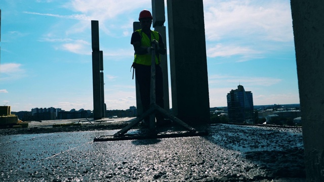 一名工程师在建筑工地平整混凝土地板。视频下载