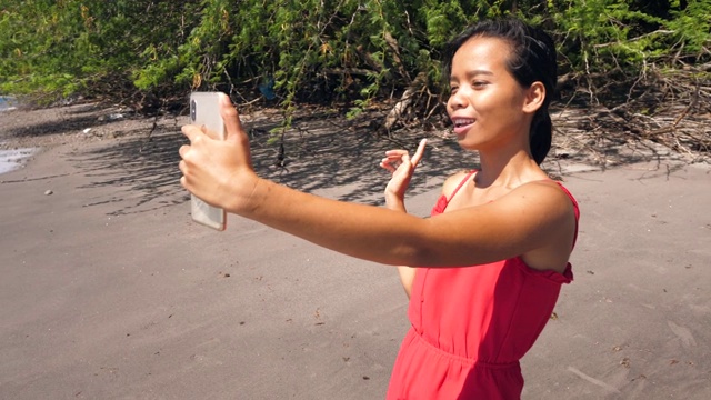 一名亚洲女博主对着拍摄社交媒体内容的摄像机说话。视频素材