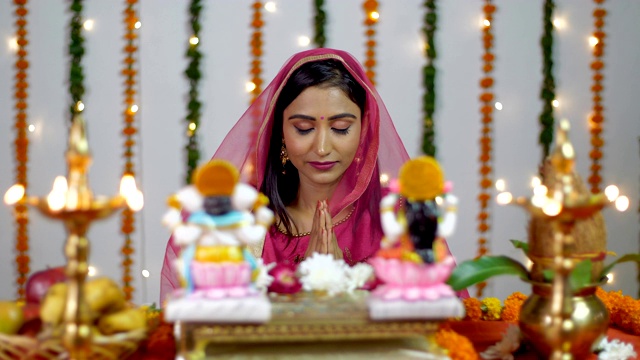 排灯节上，漂亮的印度女性在印度教神拉克希米和象头神面前祈祷视频下载