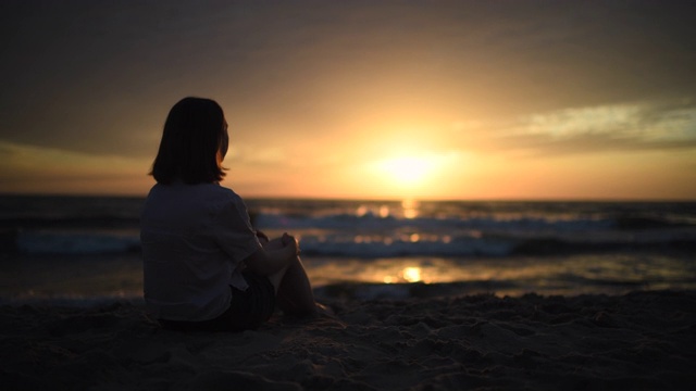 小女孩在海滩上欣赏日落视频下载