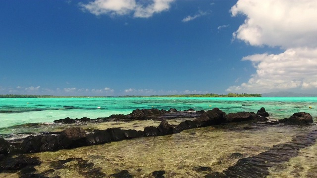 无人机在热带岛屿的岩石浅水上空飞行视频下载