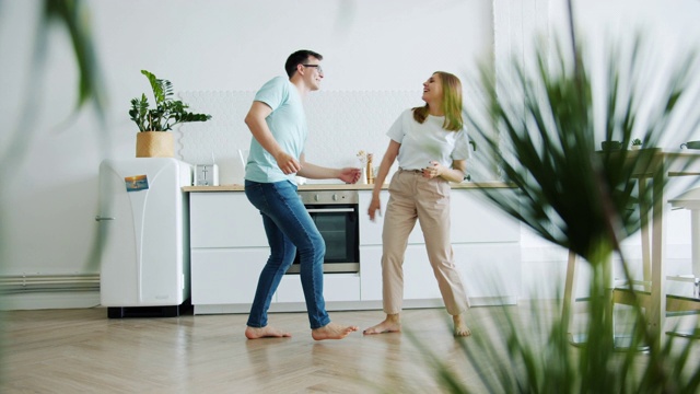 幸福家庭夫妻在厨房跳舞的慢镜头视频下载