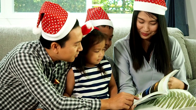 快乐亚洲一家在客厅唱生日歌，给女儿送礼物视频素材