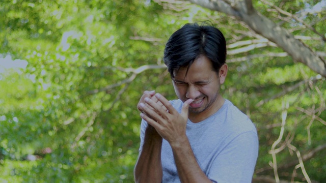 年轻的亚洲男子按摩他的手腕疼痛视频素材