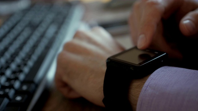 用他的智能手表应用的人。特写。商人在触摸屏上使用时髦的智能手表移动应用程序。有人在用她的智能手表触摸屏可穿戴设备。关闭了。视频素材