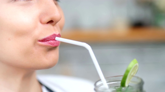特写素食女性的嘴喝健康的鸡尾酒拿着吸管的嘴唇视频素材