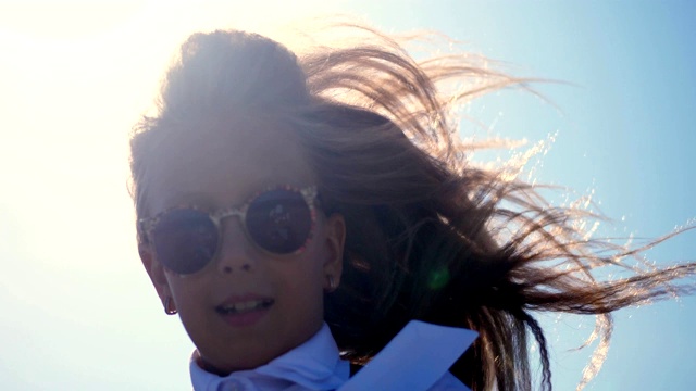肖像。戴着墨镜的少女在阳光下跳舞。她的头发在风中飘动视频素材