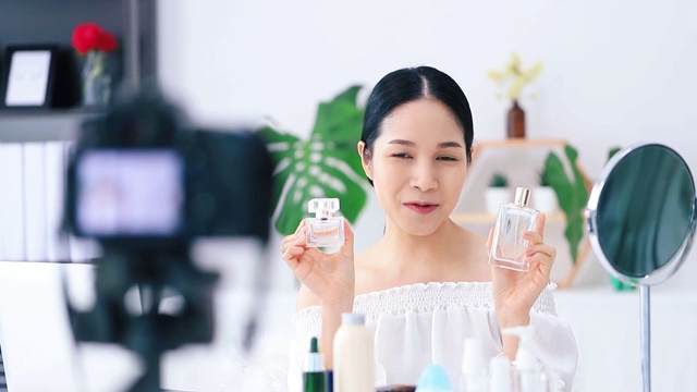 美丽的亚洲女人博客展示如何化妆和使用化妆品。在摄像机前录制在家的视频直播。商业在线影响者对社交媒体的概念。视频素材