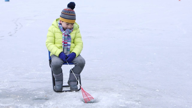 男孩在冬天享受冰嗅钓鱼/洪川，韩国视频素材