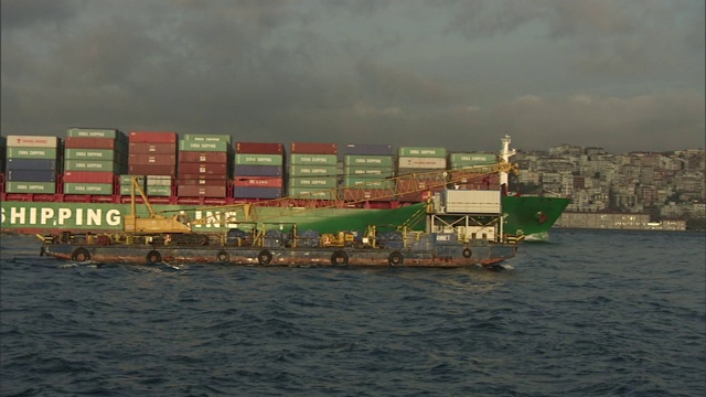 一艘满载货物的货船在波涛汹涌的水域中驶出伊斯坦布尔港。视频素材