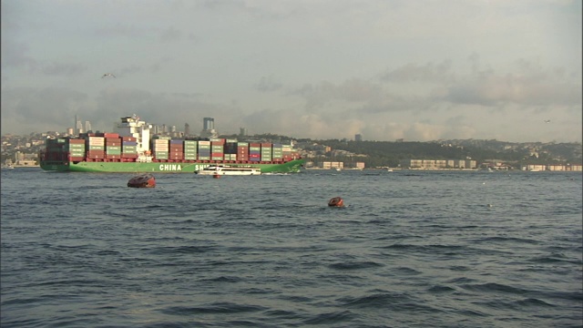 金角号上的一艘船经过伊斯坦布尔天际线附近的一艘驳船。视频素材