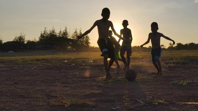 日落时分，农村的孩子们在踢足球。慢动作视频购买