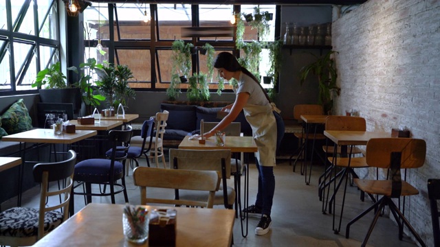 拉丁美洲的女服务员，在餐馆里整理和清洁桌子视频下载