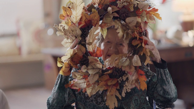 曾祖母看着她在100岁生日时收到的一个秋天的花环视频素材