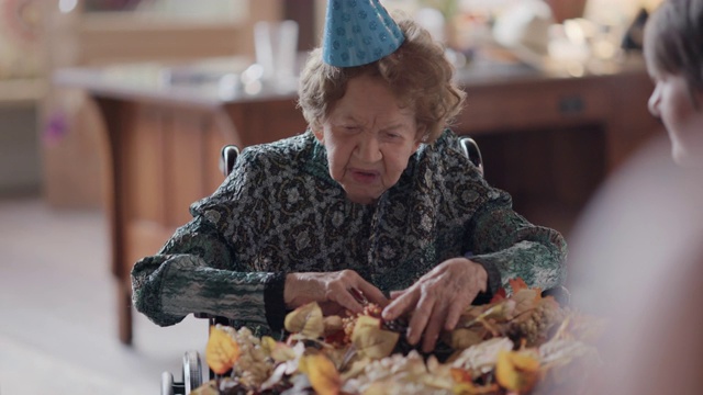 曾孙女送给曾祖母一个秋天的花环，作为她100岁生日的礼物视频素材