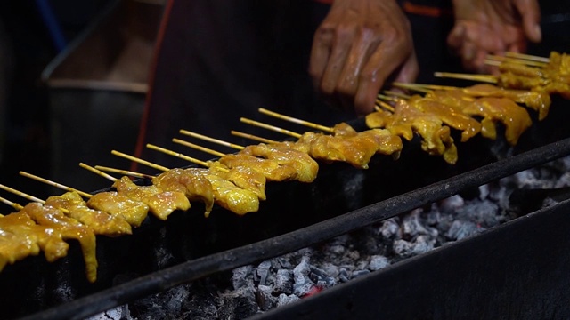 在热炭烤架上熏烤猪肉，泰国街头小吃。视频素材