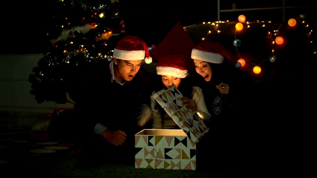 慢镜头微笑的孩子打开一个礼物盒与闪光爆炸射线在圣诞节时间视频素材