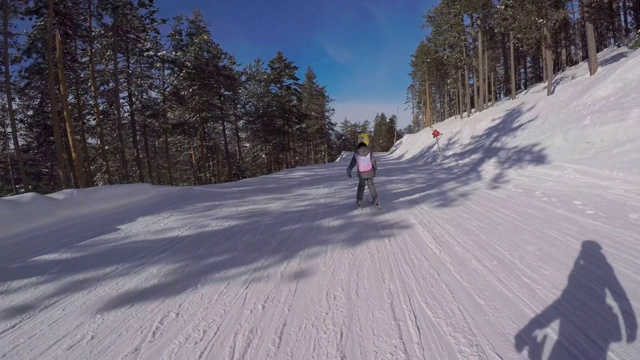 小女孩跟着滑雪教练学滑雪视频素材