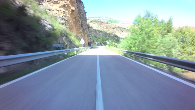 前面的汽车驾驶pov在孤独的高速公路上进出黑暗的隧道，穿过岩石景观，蓝天白云，Rincón德阿德穆斯，巴伦西亚社区视频素材