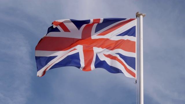 英国国旗在一个温暖、美丽、明亮的夏日骄傲地在风中飘扬的慢镜头。视频素材