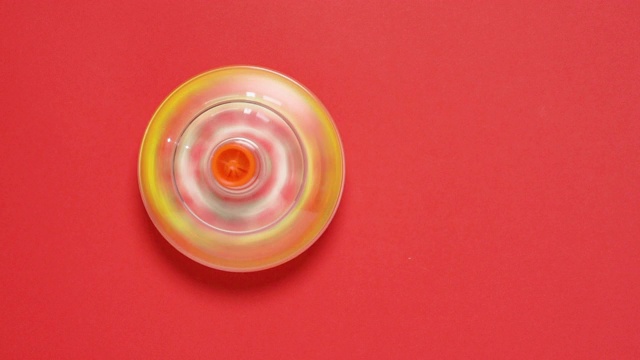 红色背景上的彩色陀螺玩具视频素材