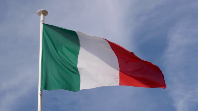 一个温暖、美丽、明亮的夏日，意大利国旗骄傲地在风中飘扬的慢镜头。视频素材