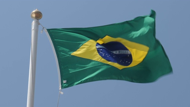 4k近距离拍摄巴西国旗在温暖、美丽、明亮的夏日骄傲地迎风飘扬的慢镜头。视频素材