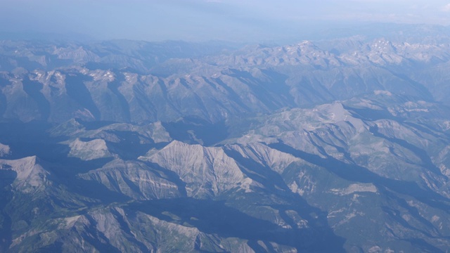 从法国尼斯起飞后不久，4k慢镜头拍摄的法国阿尔卑斯山。在一个明媚温暖的夏日，展示了法国阿尔卑斯山崎岖的山脉的全貌。视频素材