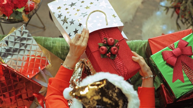 时尚的女人从购物袋里拿圣诞礼物盒视频下载