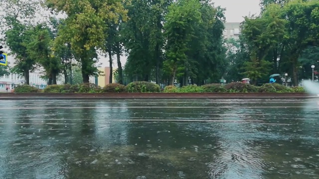 在城市的雨天，汽车在被洪水淹没的道路上行驶，从车轮下喷出水花和喷泉。恶劣和危险的交通条件。手持拍摄视频素材