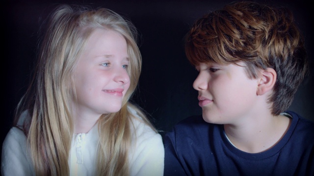一个十几岁的女孩和男孩的4k镜头微笑和拥抱可爱的相机视频下载