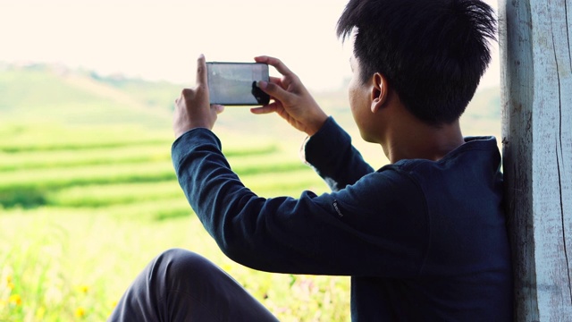 一名农村男子用智能手机拍摄稻田视频下载