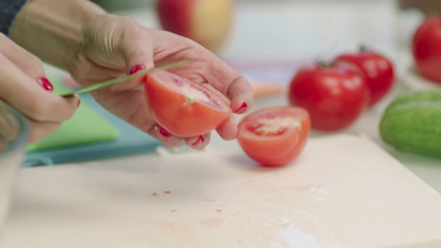 特写家庭主妇用手烹饪蔬菜沙拉。厨房餐桌上的健康食物视频素材