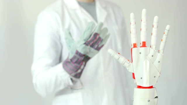 工程师正在测试机器人假肢手，通过传感器重复他的手在手套中的运动。肌肉神经移植技术视频下载