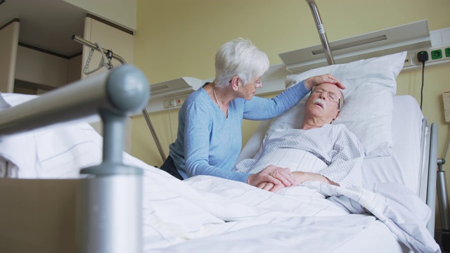老年妇女在病床上安慰不安的丈夫视频下载