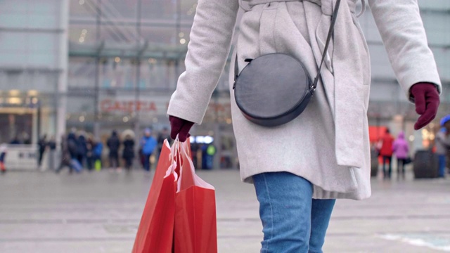 低贱的女人拿着购物袋走在街上视频素材