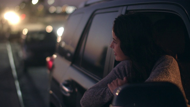 一名年轻女子坐在车里望着窗外视频素材