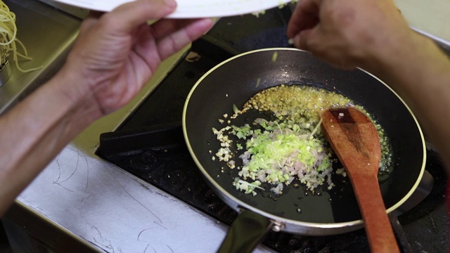 特写厨师准备食物在煎锅和倒蔬菜在锅煮。视频素材