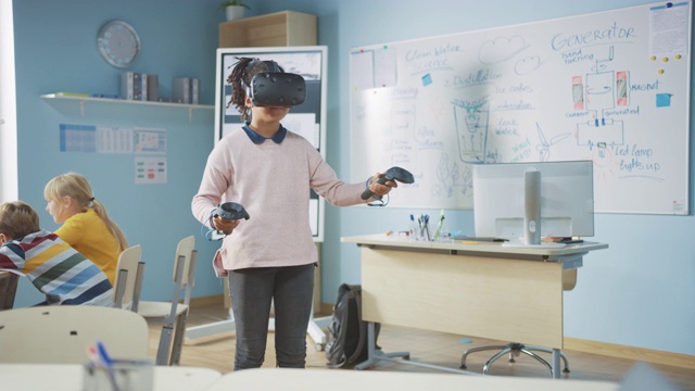 小学计算机科学课:可爱的女孩戴着增强现实耳机和使用控制器学习虚拟现实课程兴奋，好奇和感兴趣的知识视频素材