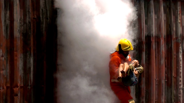 在帮助儿童受害者后，勇敢的消防队员从着火的建筑中跑出来的特写视频素材