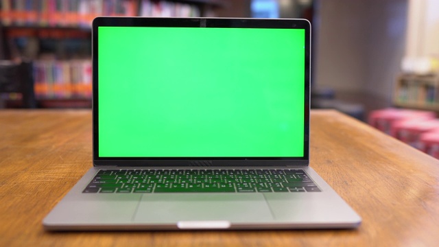 图书馆里绿色屏幕的笔记本电脑，色度键视频素材